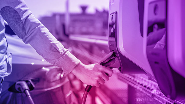 Hand mit Ladestecker an Mennekes Wallbox