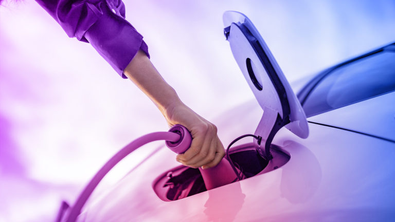 Elektroauto wird geladen, Hand an Ladestecker