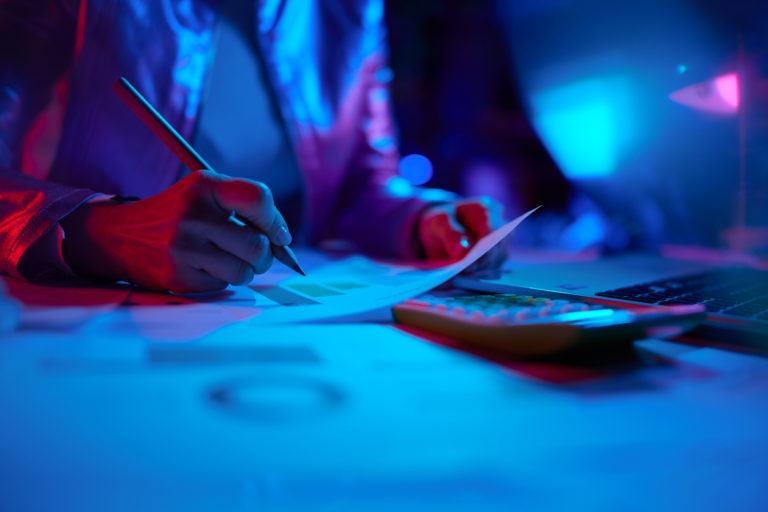 Nahaufnahme Geschäftsfrau mit Taschenrechner und Grafiken