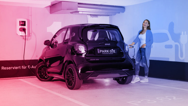 Referenz Park On: Frau lädt Smart an Wallbox in Tiefgarage