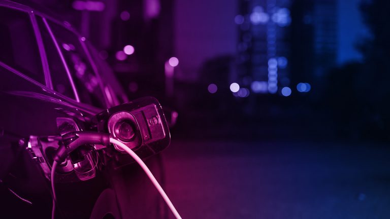 Ein Elektroauto lädt Nachts in der Stadt